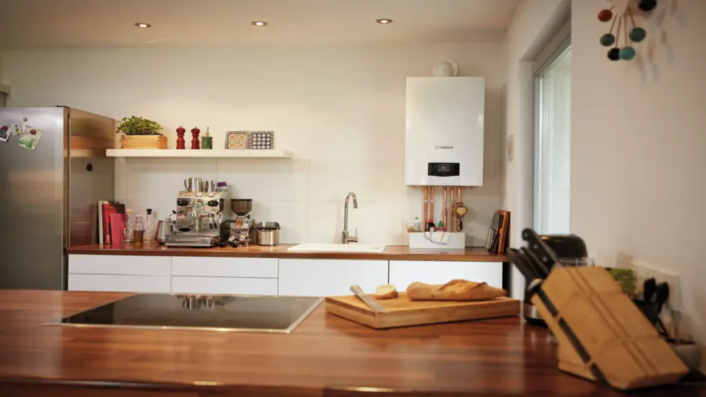 A kitchen with a refrigerator, cooker, and sink. Featuring Vailant Eco Tech boilers from Kesseltek.